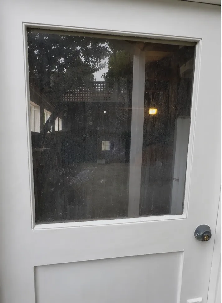 Spotted residential door glass before professional cleaning